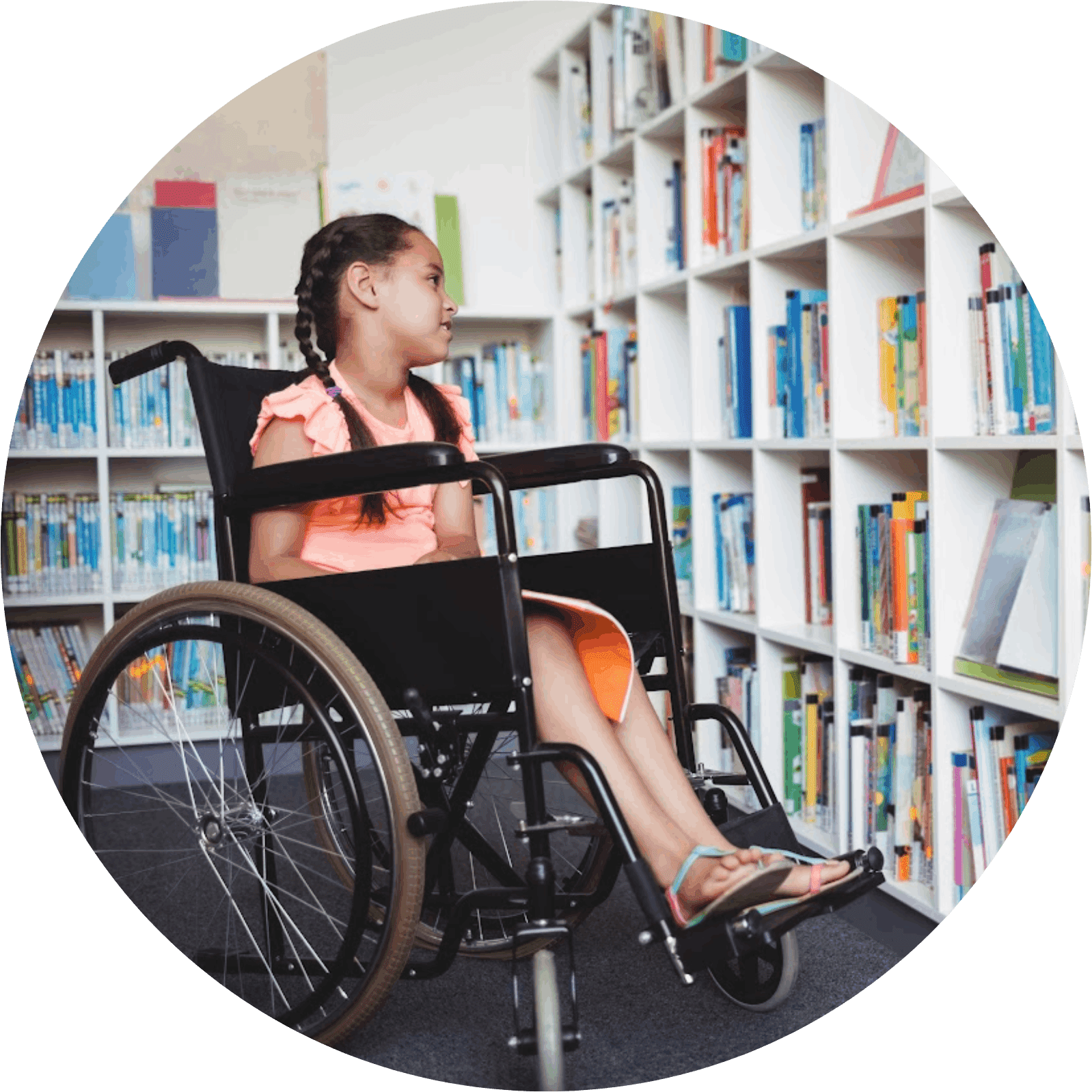 A girl in a wheelchair sitting on the floor